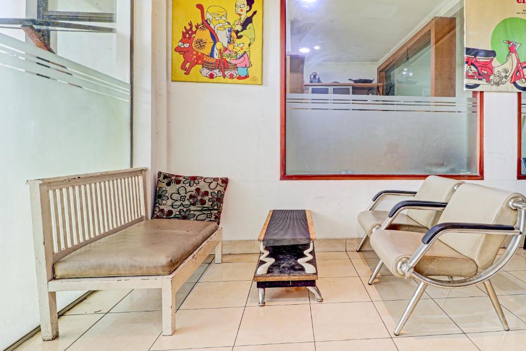 a waiting room with chairs and a bench at OYO 90218 Ubaran Guest House in Bandung