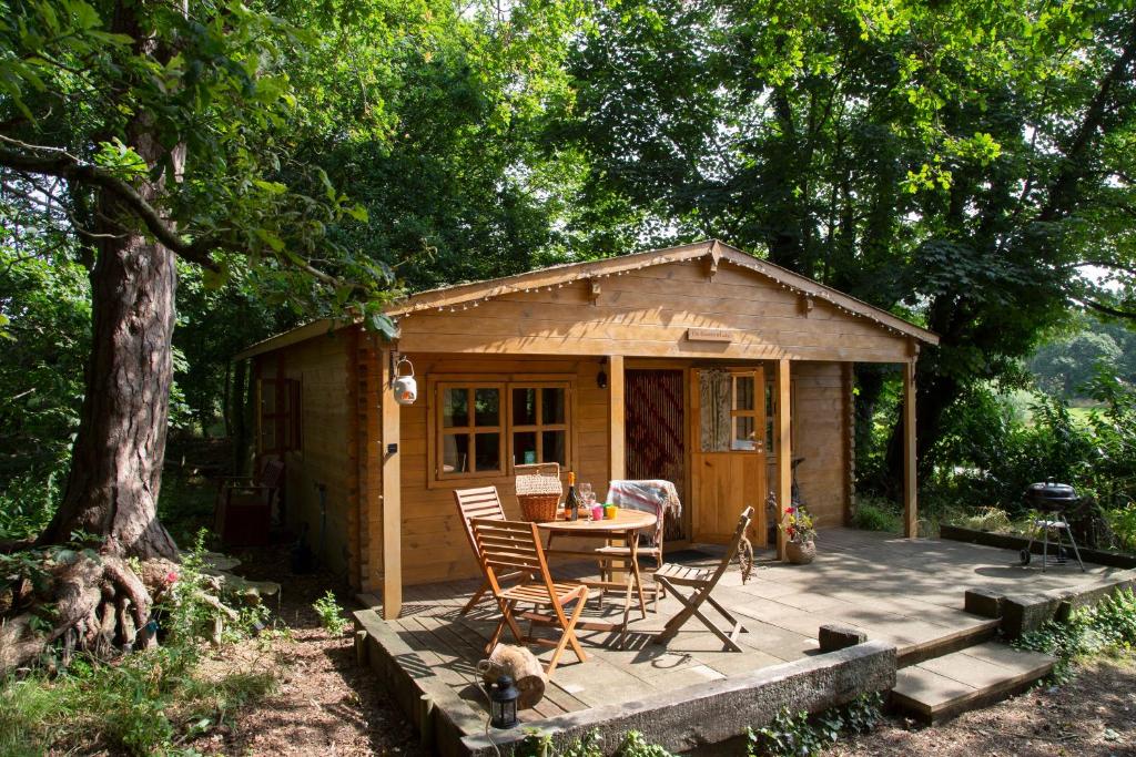 a small cabin with a table and chairs on a deck at West Stow Pods in Bury St Edmunds in West Stow