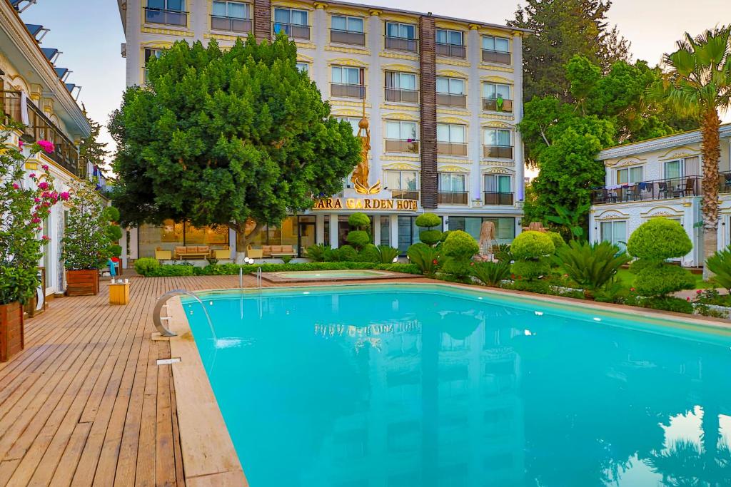 a swimming pool in front of a hotel at Lara Garden Hotel in Lara