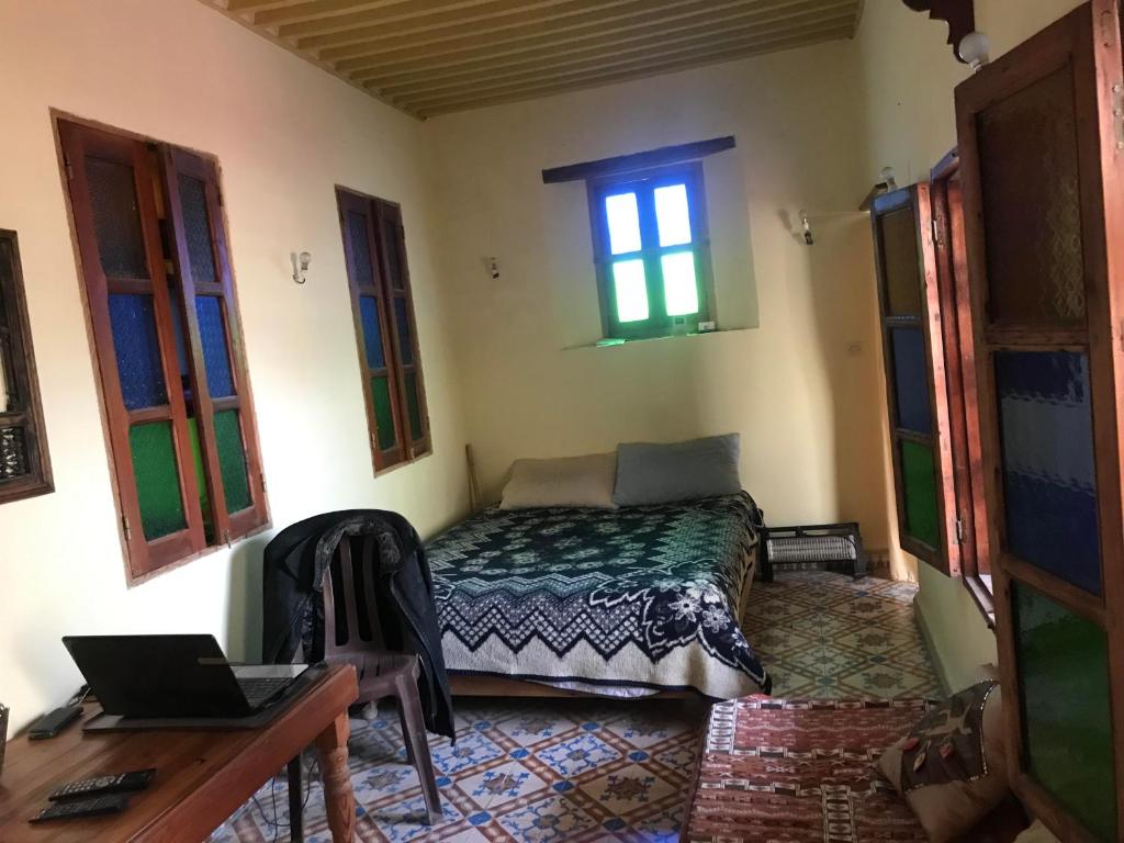 a bedroom with a bed and a desk and a window at studio bab guissa in Fès al Bali