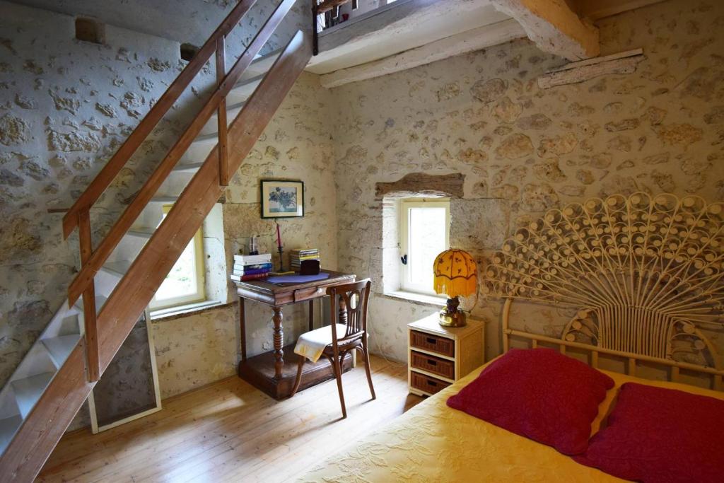 1 dormitorio con escalera, 1 cama y escritorio en Maison de caractère à Castella - Clévacances 3 clés, en Castella