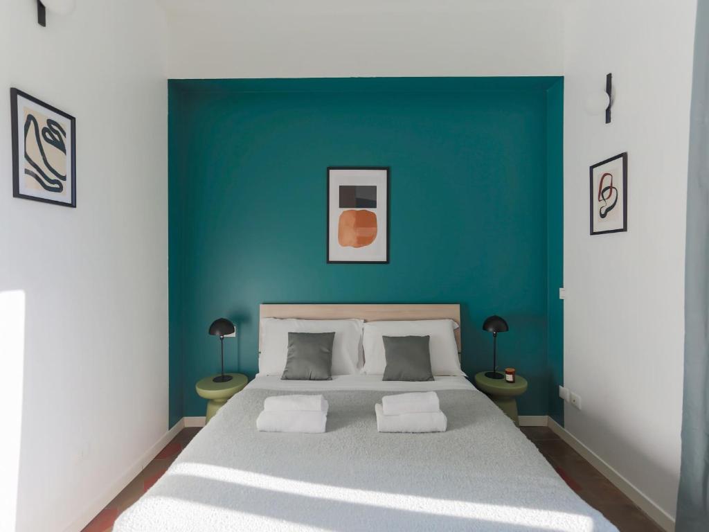 a bedroom with a large bed with a blue wall at The Best Rent - Spacious two bedrooms apartment in Porta Romana in Milan
