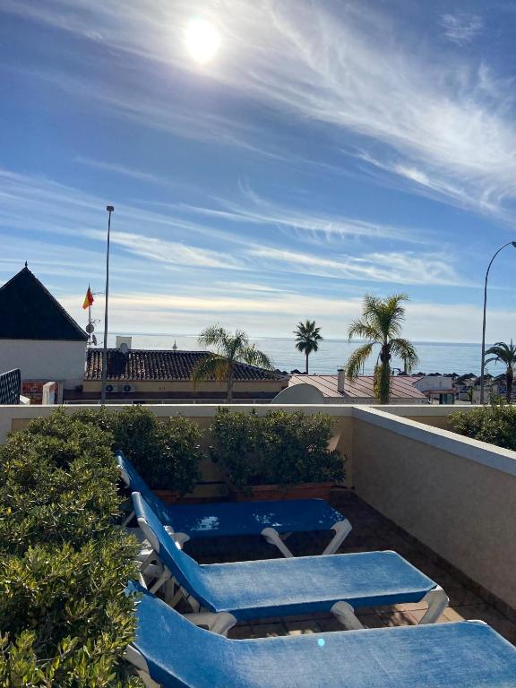 two lounge chairs and a swimming pool on a roof at Apartamentos HC Burriana Playa in Nerja