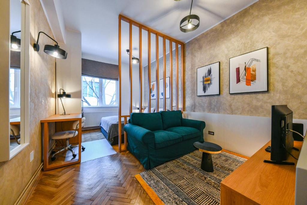 a living room with a green couch and a television at Designer Central Getaway in Cluj-Napoca