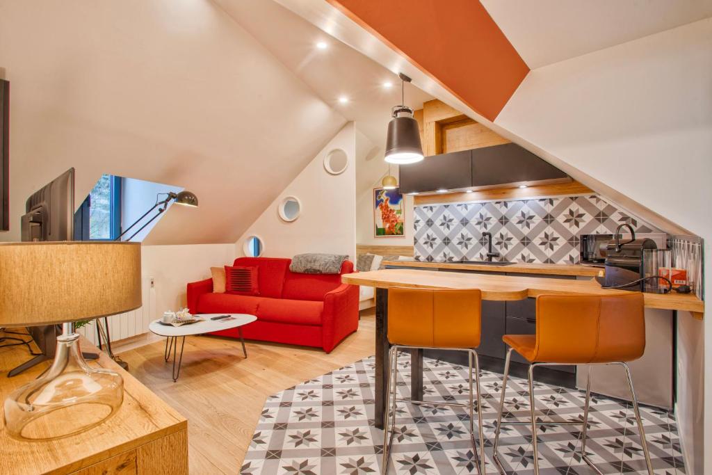 a living room with a red couch and a table at Nid douillet à 30 mètres de la grande plage de Houlgate - RESIDENCE LA VAGUE - in Houlgate