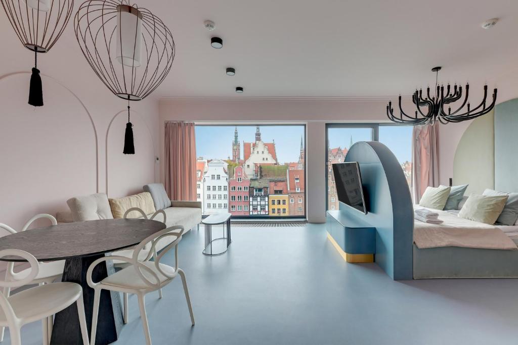 a living room with a bed and a table and chairs at Deo Plaza Basen & Sauna by Grand Apartments in Gdańsk