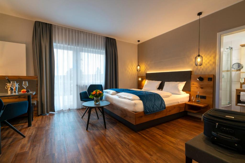 1 dormitorio con cama, escritorio y mesa en Weingut Schreieck VINOTEL & GUTSHAUS en Sankt Martin