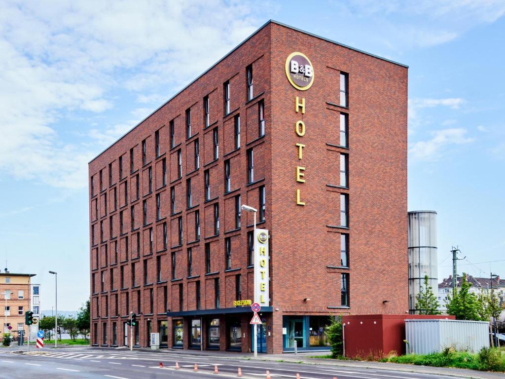 un bâtiment en briques avec un panneau sur son côté dans l'établissement B&B Hotel Mainz-Hbf, à Mayence