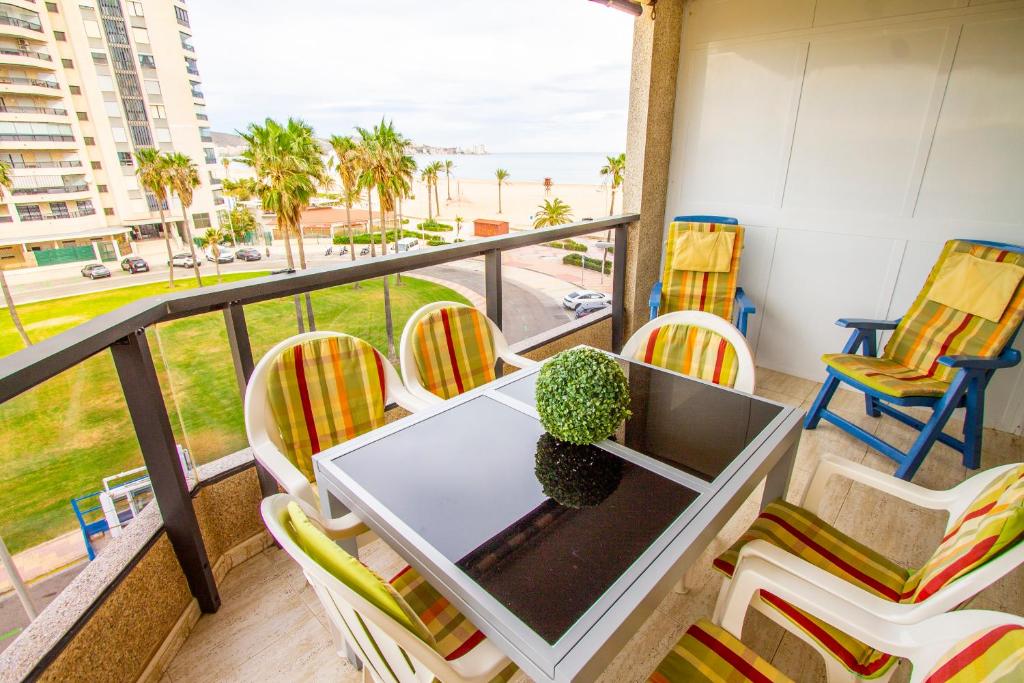 einen Tisch und Stühle auf einem Balkon mit Meerblick in der Unterkunft ESPACIO 3 - Primera Línea de Playa in Cullera