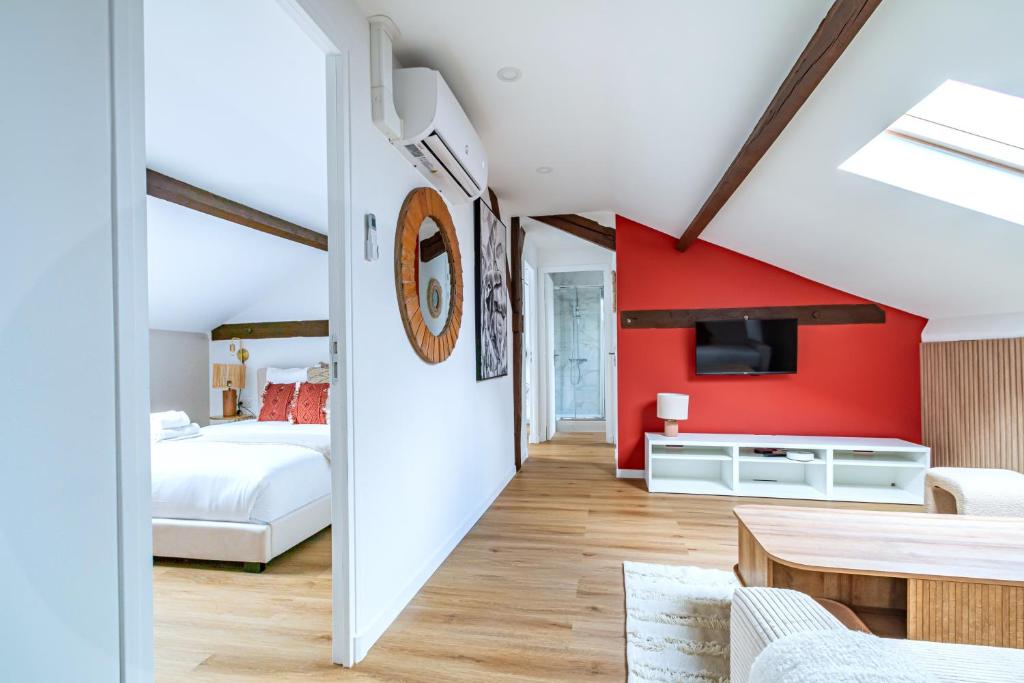 une chambre avec un mur aux accents rouges et une chambre dans l'établissement Appartement proche Paris 13ème arrondissement, à Ivry-sur-Seine