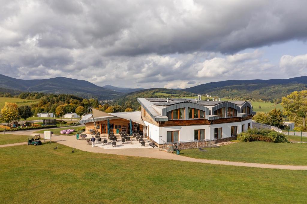 an aerial view of a house with mountains in the background at Grund Resort Golf and Ski in Mladé Buky