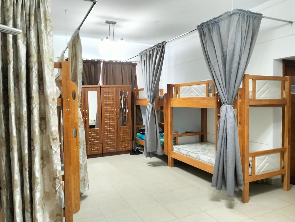 a room with bunk beds and curtains in a room at Executive Becholars Hostel in Dubai