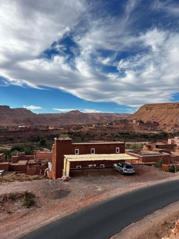 un coche aparcado frente a un edificio en el desierto en Kasbah Tigmi El Janoub, en Aït Ben Haddou