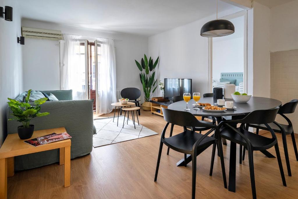 sala de estar con mesa, sillas y sofá en Habitat Apartments Art en Barcelona