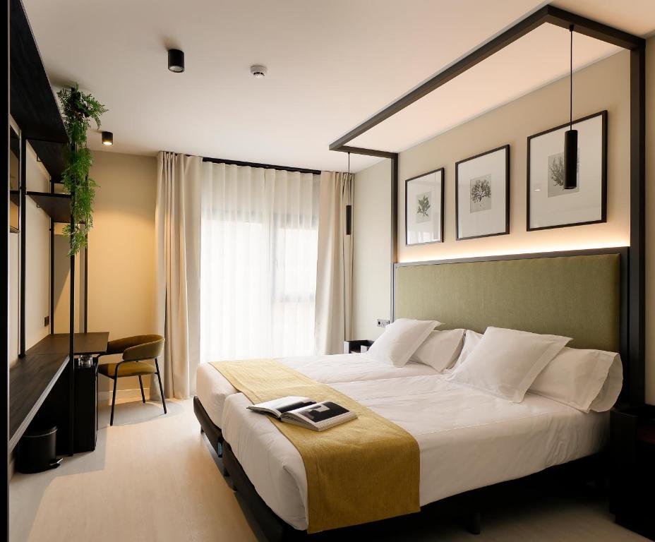 オビエドにあるNuvō Hotel Boutiqueの大きなベッドとデスクが備わるホテルルームです。