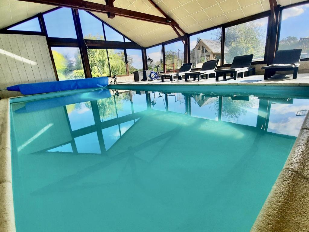 a swimming pool with blue water and chairs in it at O Gîte Bleu 