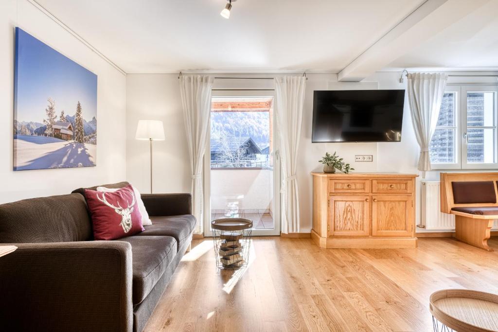 uma sala de estar com um sofá e uma televisão em 2-Zimmer Ferienwohnung Rüti mit SW-Balkon em Brand