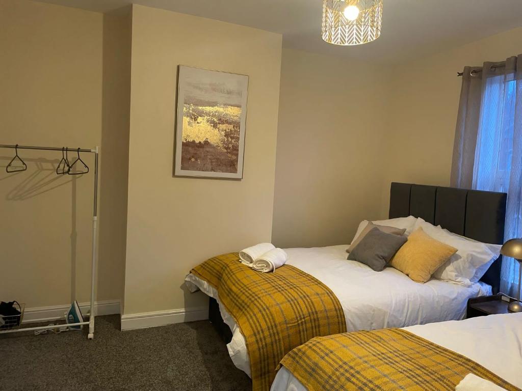 a bedroom with two beds and a chandelier at St James House - Sleeps 8! in Leeds
