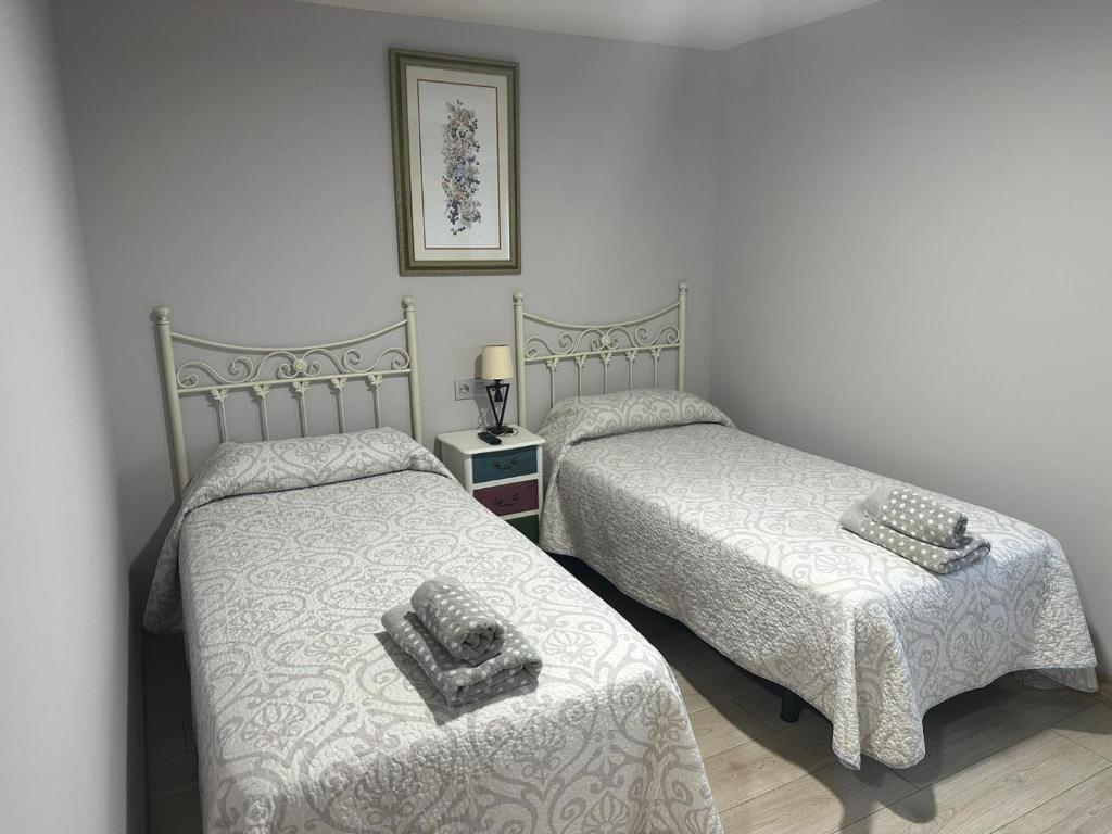 ein Schlafzimmer mit 2 Betten und Handtüchern darauf in der Unterkunft HOTEL RURAL LOS FAROLES in Huérmeces