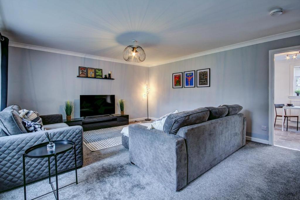sala de estar con sofá y TV en Ravenscroft - Coorie Doon, en Irvine