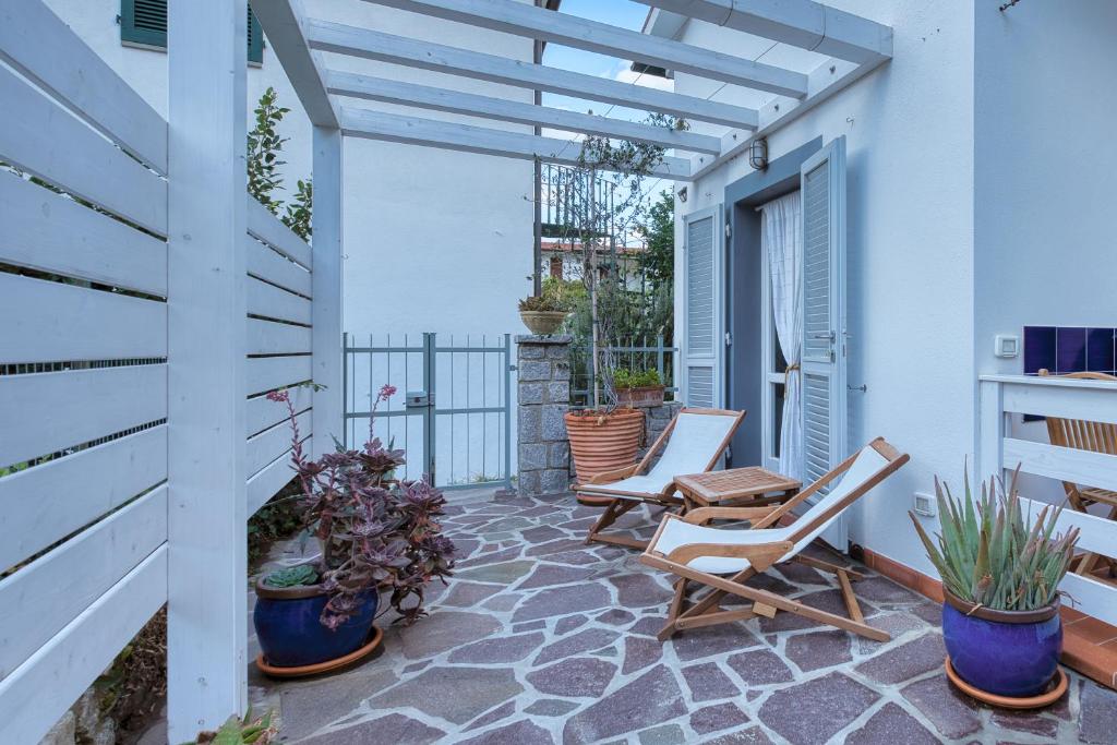 eine Terrasse mit Stühlen und Topfpflanzen auf einem Gebäude in der Unterkunft Casa Celeste - Goelba in Pomonte