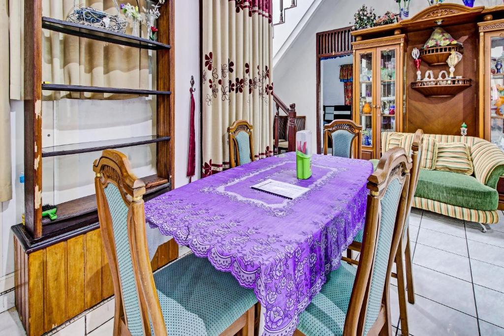 OYO 90543 An-nur Guest House Syariah في كونيغان: طاولة في غرفة مع قطعة قماش أرجوانية