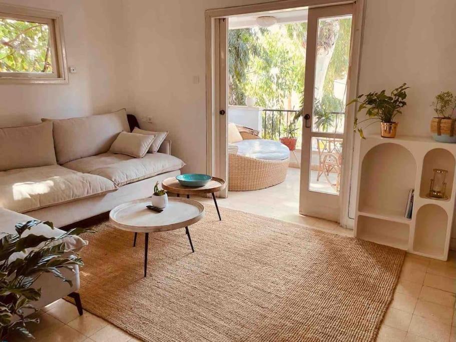 a living room with a couch and a table at כפר בלב העיר המקום ביותר בתל אביב in Tel Aviv