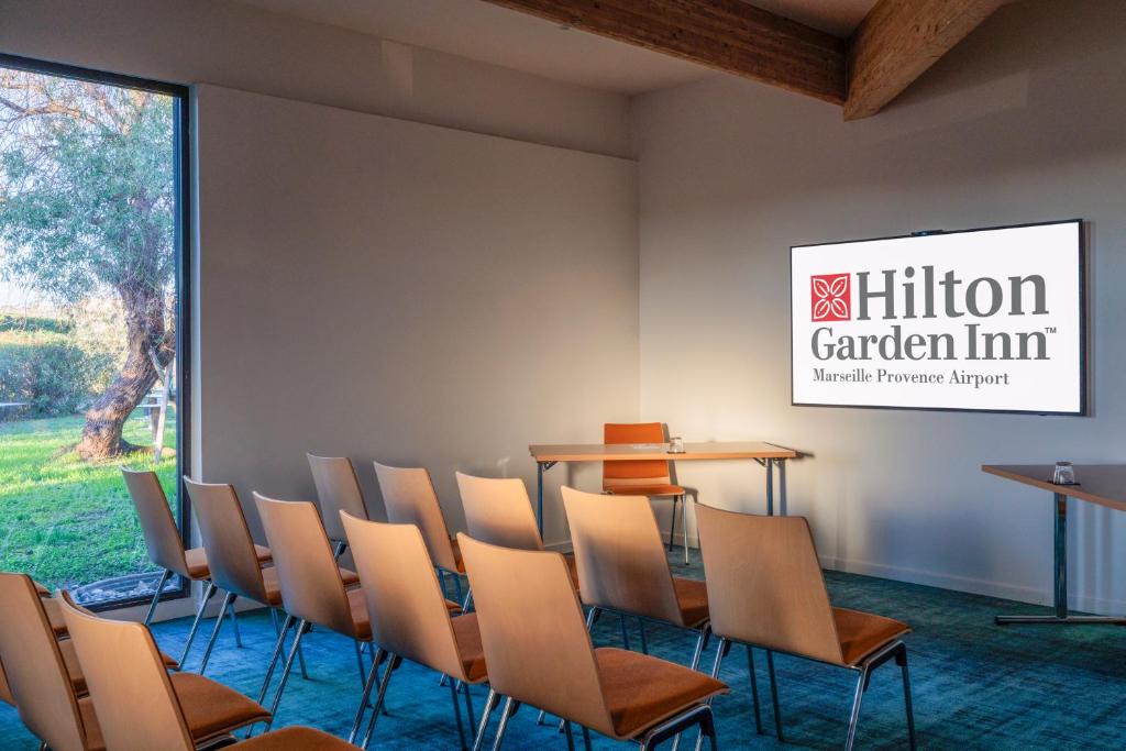 a conference room with a table and chairs at Hilton Garden Inn Marseille Provence Airport in Marignane