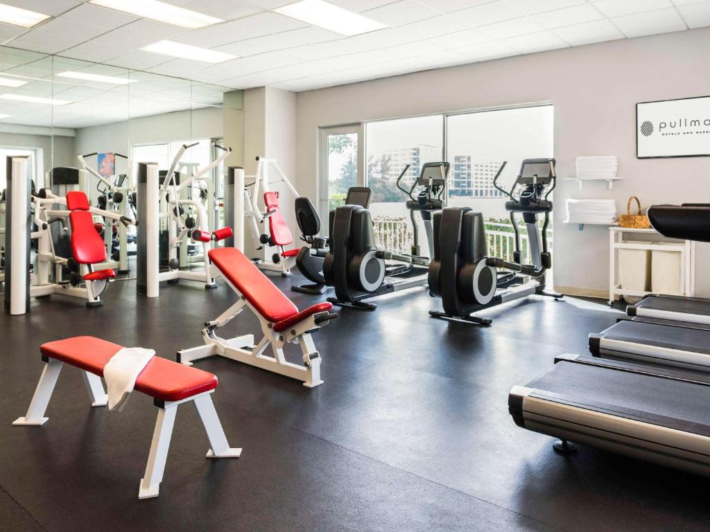 a gym with treadmills and exercise equipment in a room at Pullman Miami Airport in Miami