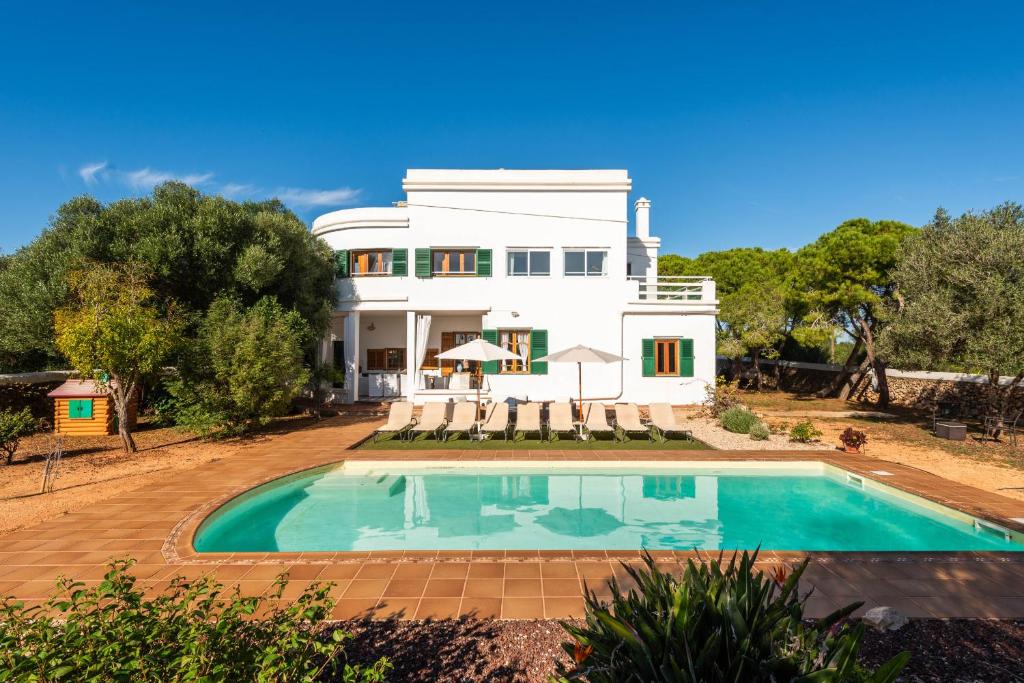 una casa con piscina frente a ella en Villa Son Prats, en Cala Santandria