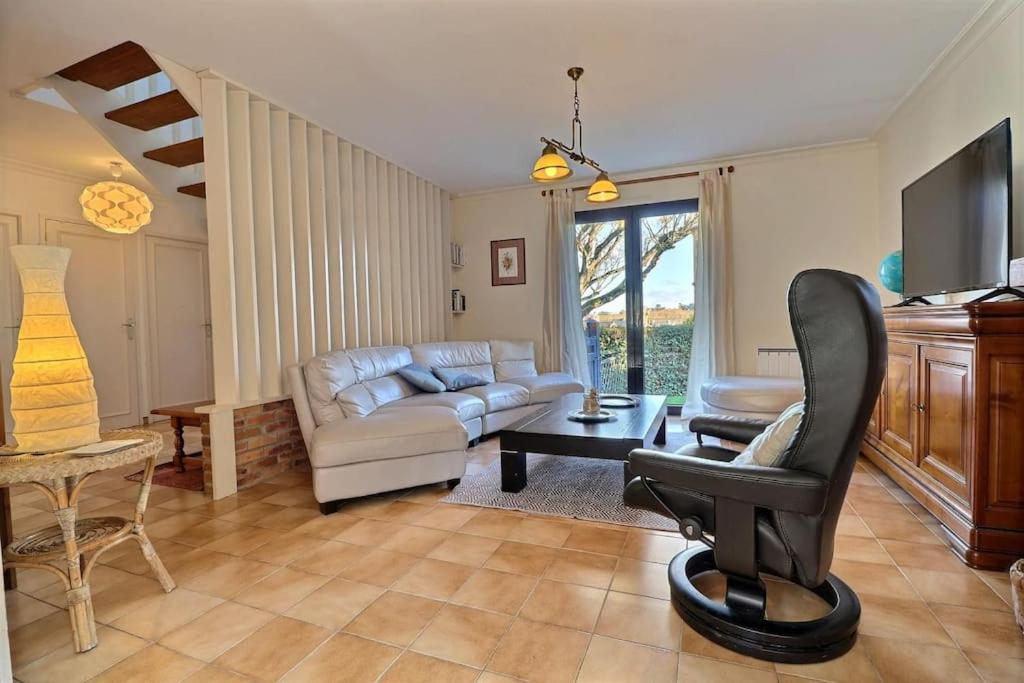 sala de estar con sofá y silla en Maison Saint LU, en Saint-Lunaire
