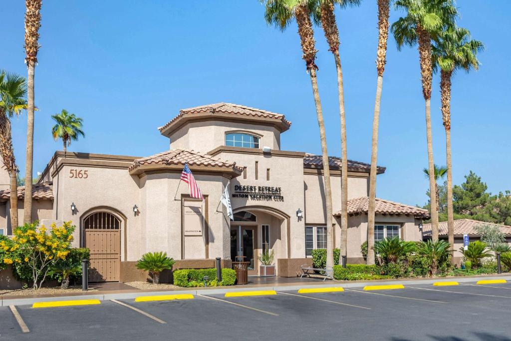 a building with palm trees in a parking lot at Hilton Vacation Club Desert Retreat Las Vegas in Las Vegas