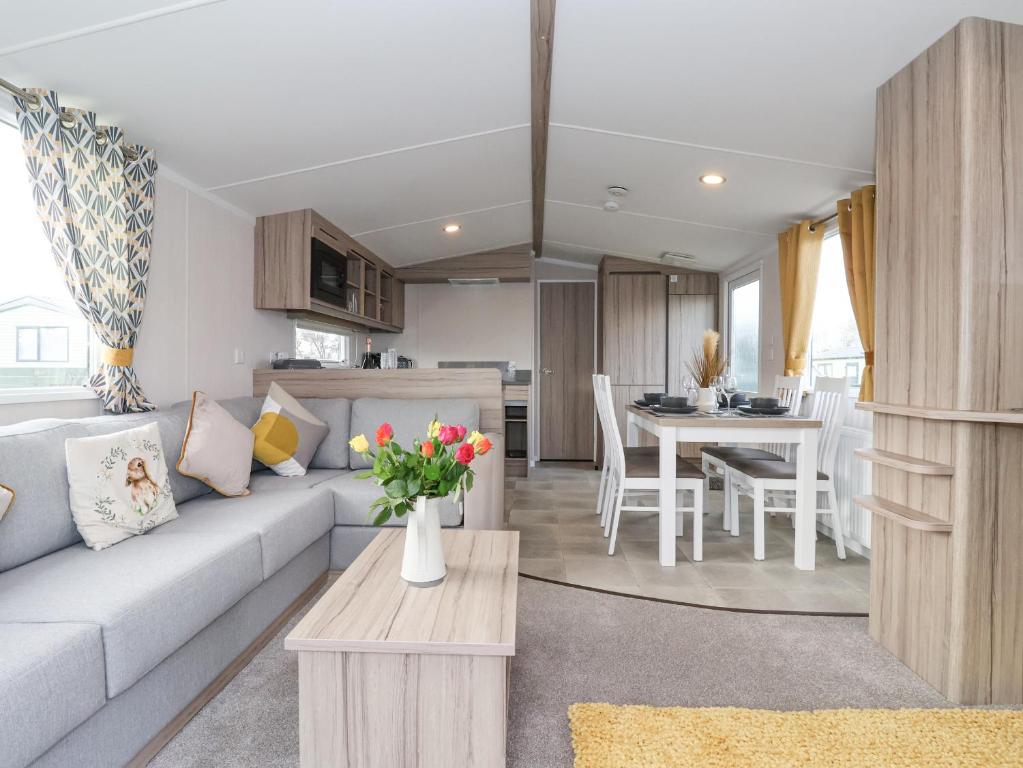 a living room and kitchen with a couch and a table at Lazy Dayz Lodge in Ganton