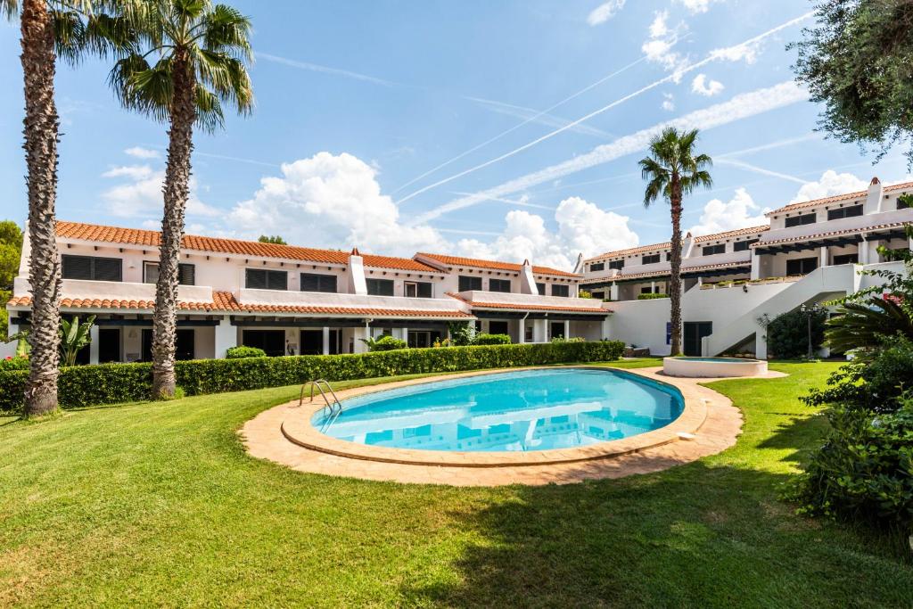 una vista exterior de un complejo con piscina en Apartamento Arenal Jardin, en Arenal d'en Castell