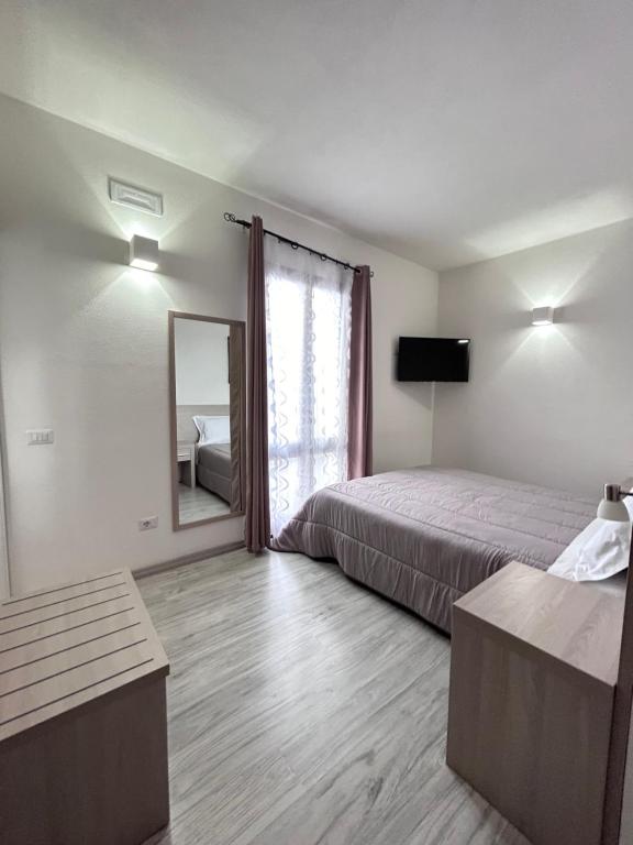 ein Hotelzimmer mit einem Bett und einem Spiegel in der Unterkunft Affittacamere In Centro in Tortolì