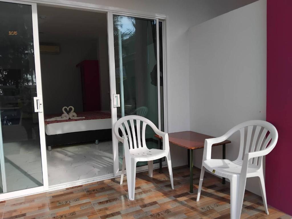 - une salle à manger avec deux chaises, une table et un lit dans l'établissement เขาหลัก ซัมเมอร์เฮาส์ 2, à Khao Lak