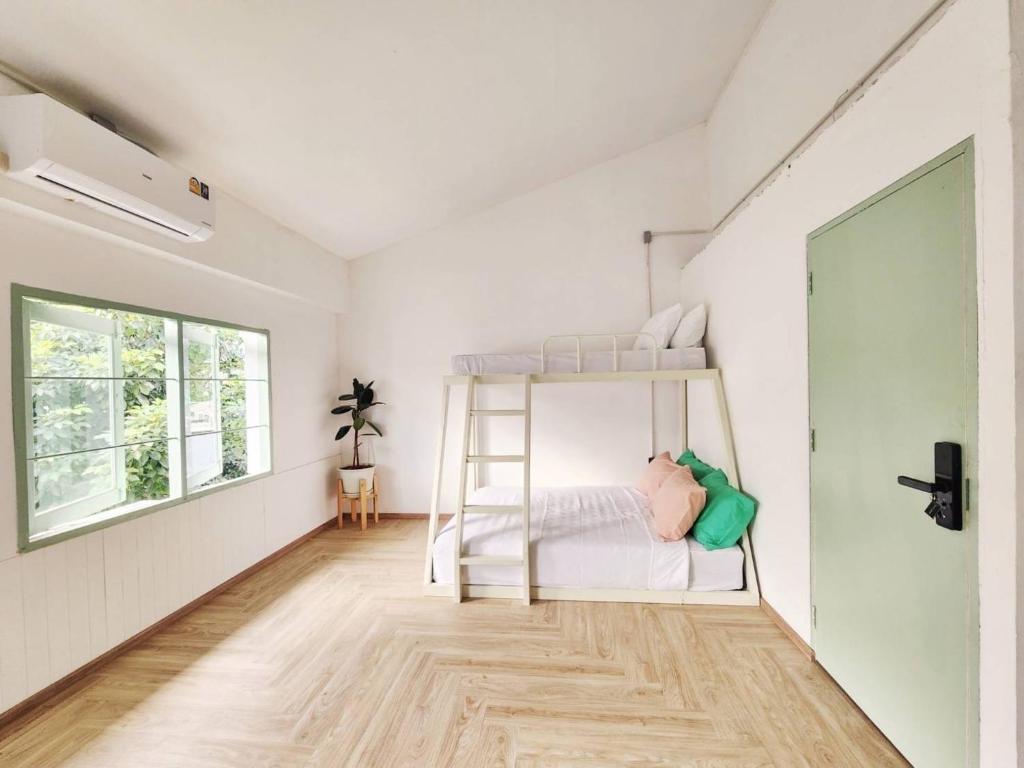 ein Schlafzimmer mit einem Etagenbett in einem weißen Zimmer in der Unterkunft The Greens Old Town Bangkok in Bangkok