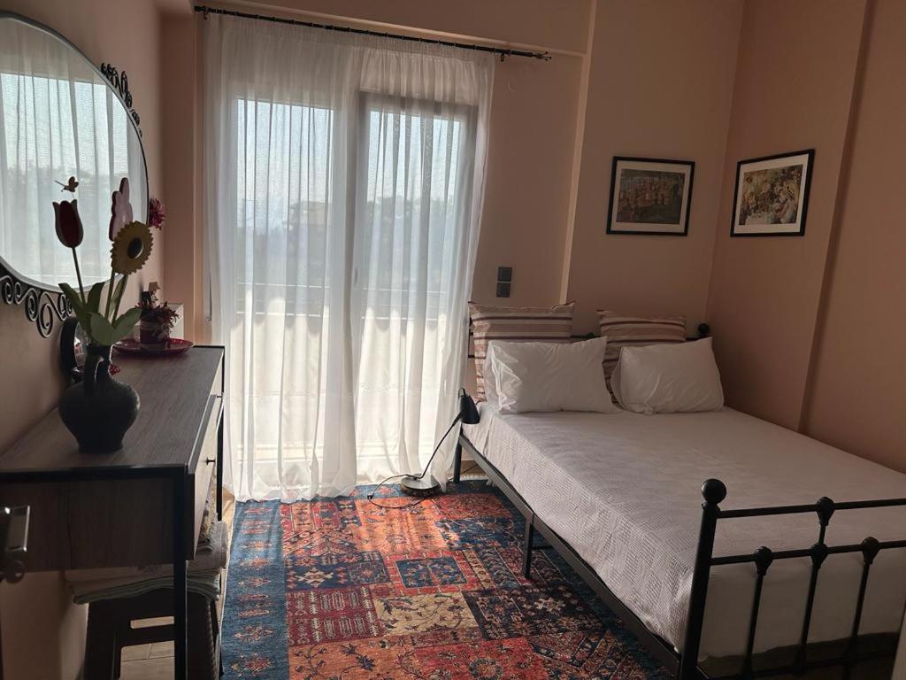 a bedroom with a bed and a large window at Αθανάσιος in Ioannina