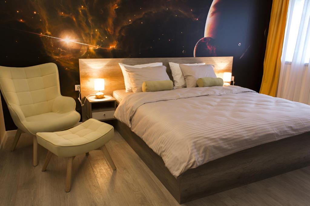 een slaapkamer met een bed en een stoel bij Galaxy Apartments in Belgrado