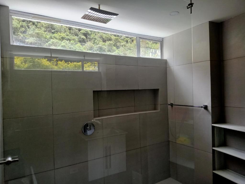 a bathroom with a shower with a window at mirador samsara in La Calera