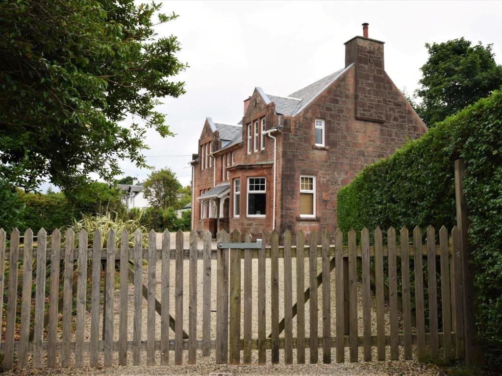 a wooden fence in front of a brick house at 5 Bed in Brodick CA016 in Brodick