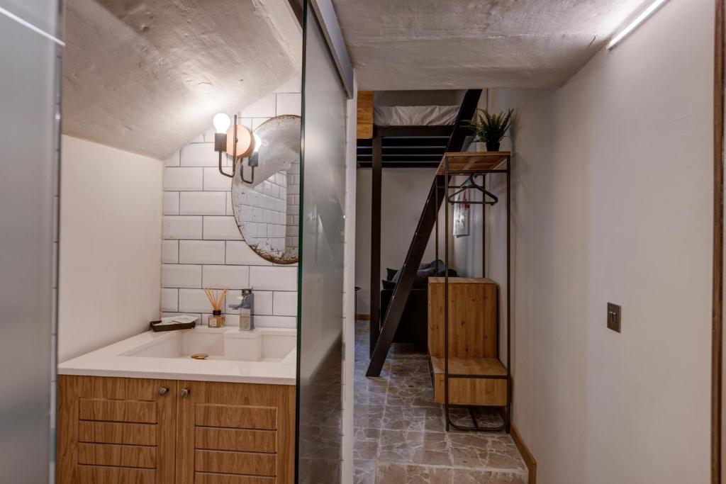 een badkamer met een wastafel en een trap in een kamer bij DESIGNER'S 2BR APARTMENT - SLIEMA FERRIES in Sliema