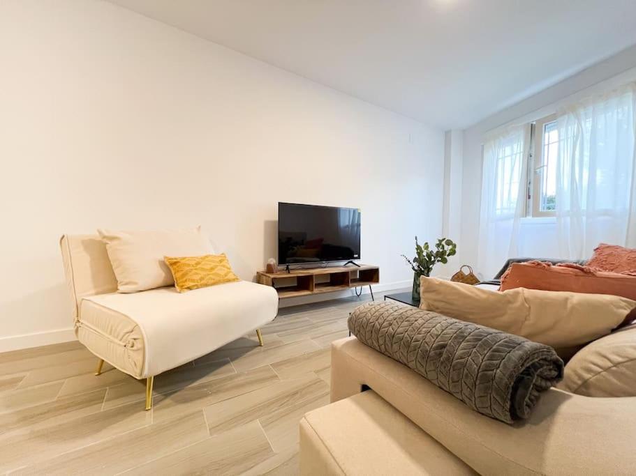 sala de estar con sofá y TV en Apartamentos Gredos 101, en Jaraíz de la Vera