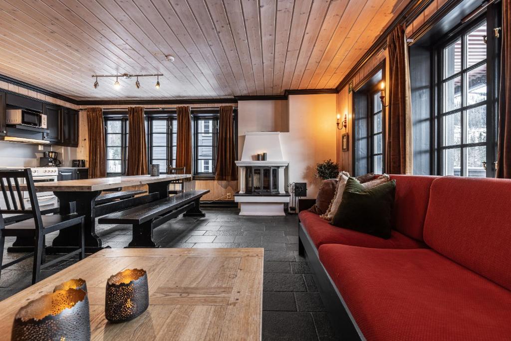 uma sala de estar com um sofá vermelho e uma mesa em Tinden Apartments em Hemsedal