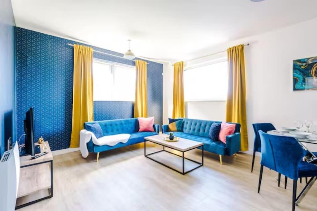 uma sala de estar com sofás azuis e uma televisão em 2 Bedroom Manchester Gem Ancoats em Manchester