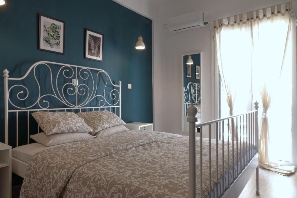 um quarto com uma cama e uma parede azul em You & Me Cozy Apartments em Atenas