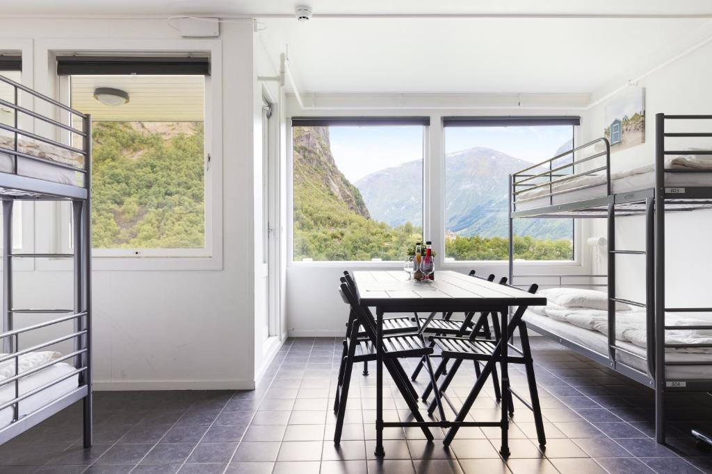 a room with a table and two bunk beds at Trolltunga Hostel in Tveit