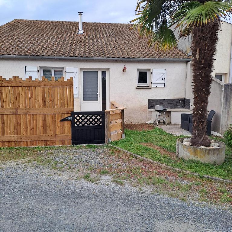 a house with a wooden gate and a fence at LES BOUCHOLEURS in Yves