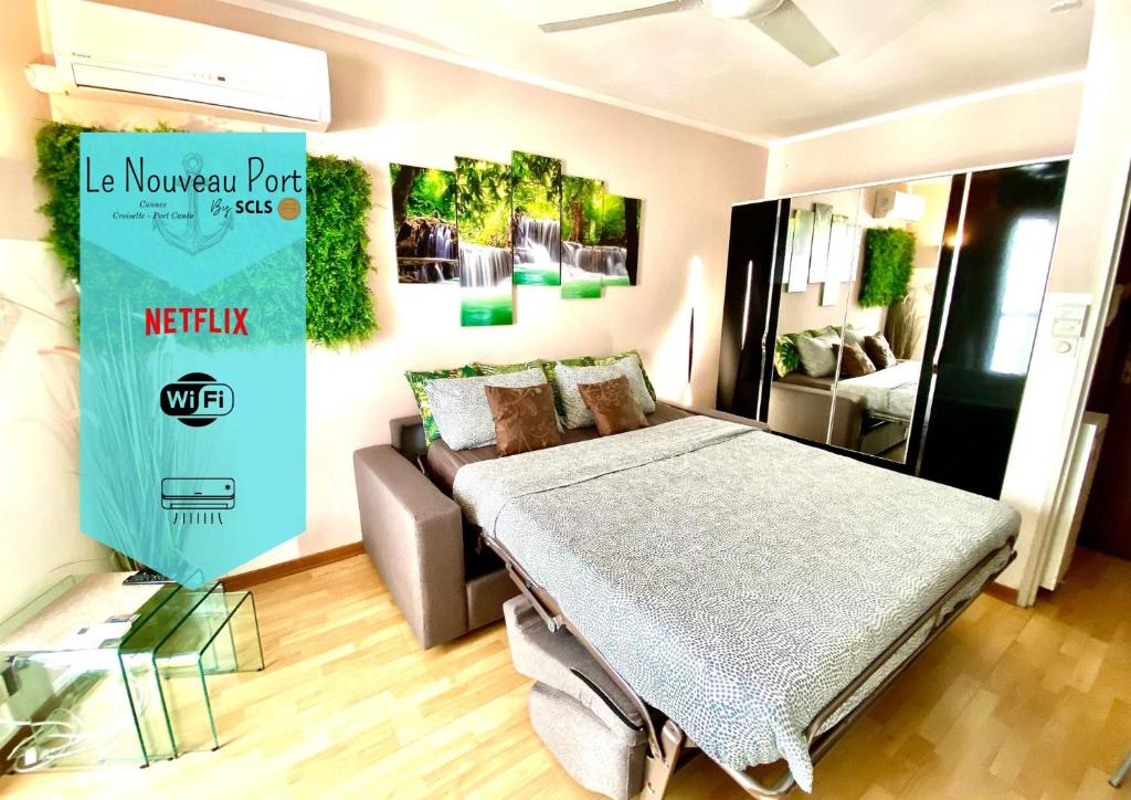 een slaapkamer met een bed en een bank erin bij Le Nouveau Port By SCLS Locations in Cannes