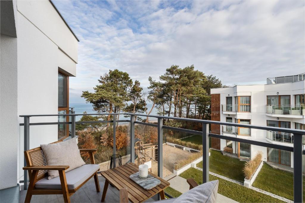 balkon ze stołem i krzesłami na budynku w obiekcie LET'S SEA - 4 Person - Premium Baltic Apartment with Sea View nad SPA access w Gąskach